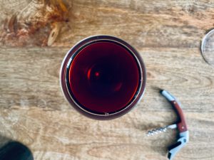 glass of non alcoholic red wine with a corkscrew